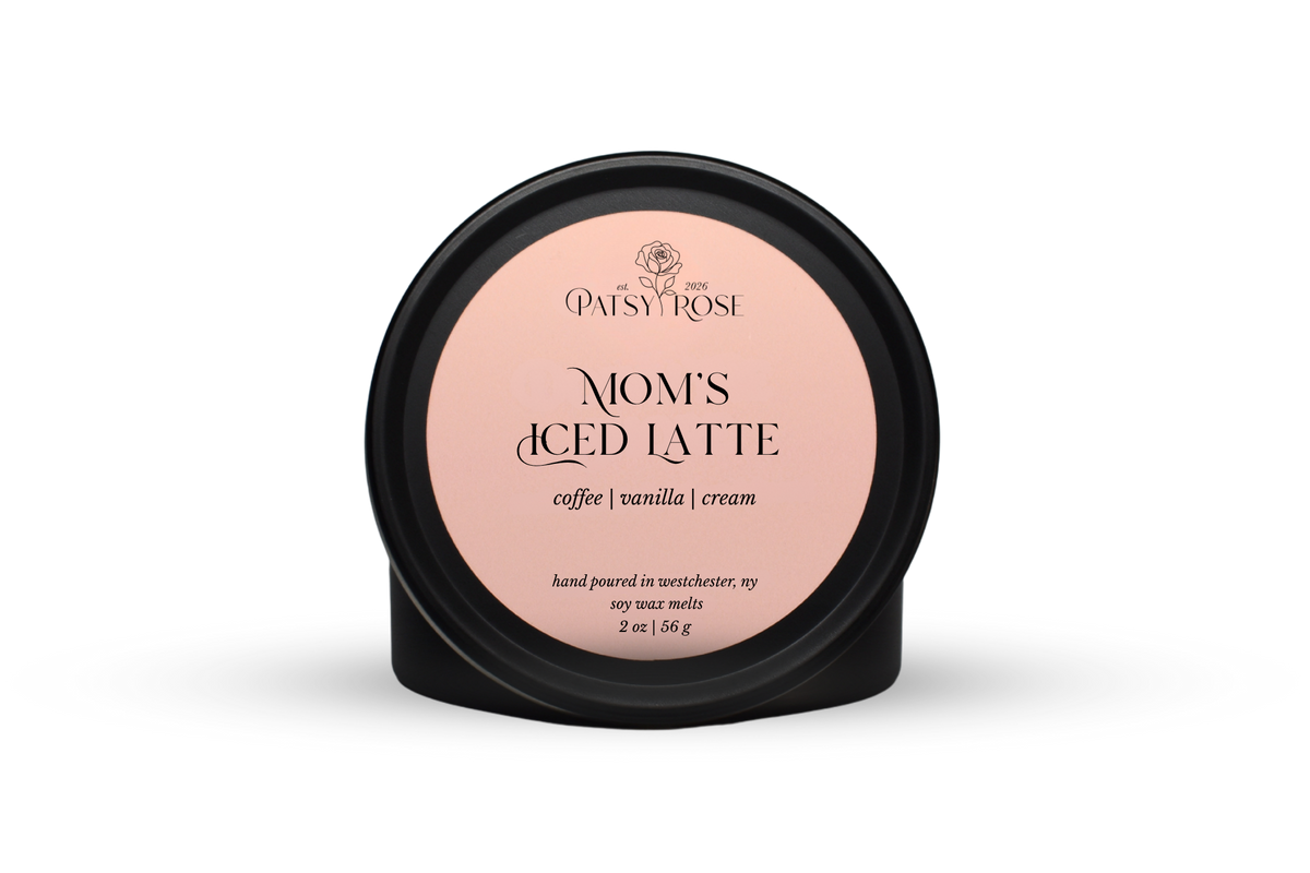 Hand-poured soy wax melts made by Patsy Rose with black tins and a peach label that says "Mom's Iced Latte" with scent notes of "coffee, vanilla, cream".
