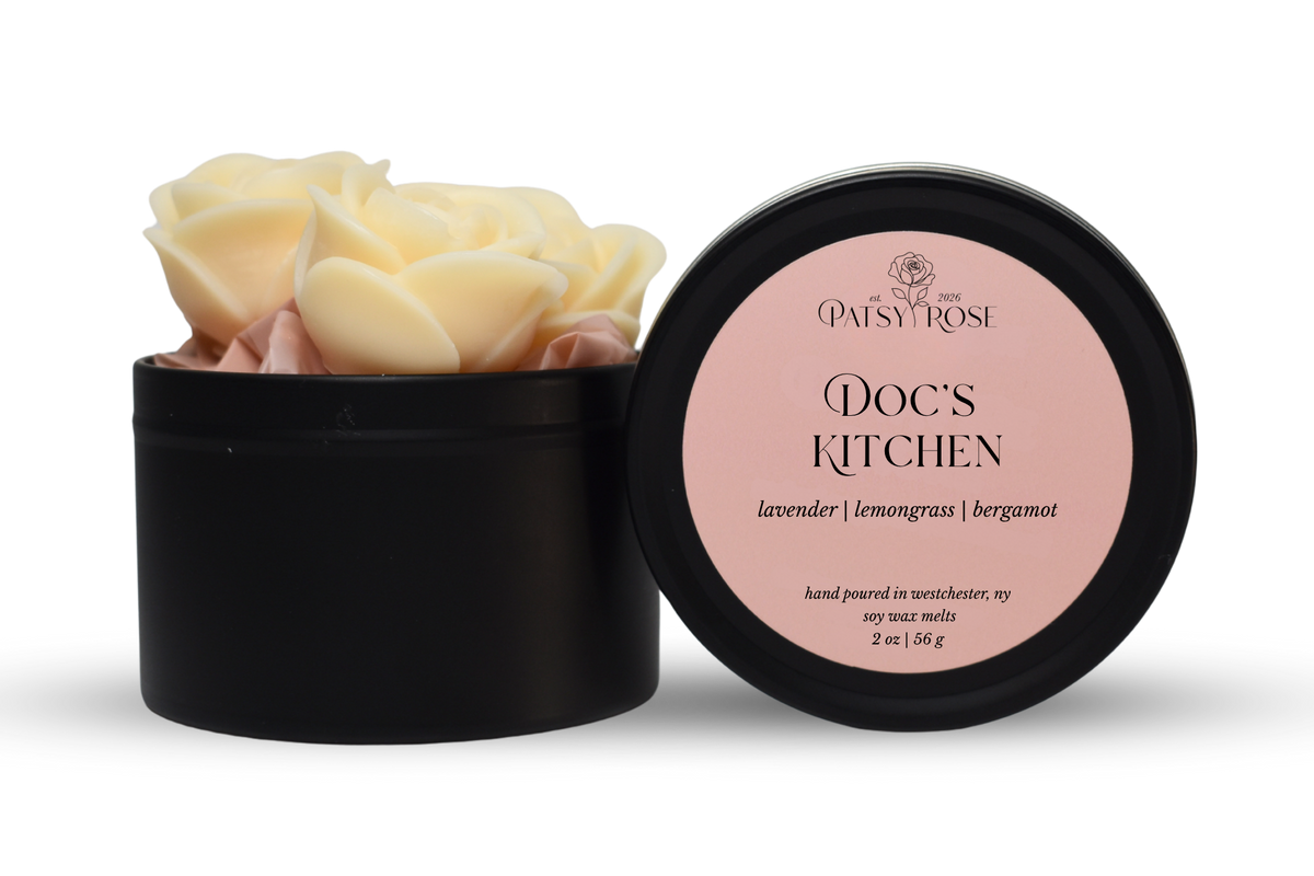 Hand-poured, rose shaped soy wax melts made by Patsy Rose with black tins and a peach label that says "Doc's Kitchen" with scent notes of "lavender, lemongrass, bergamot".