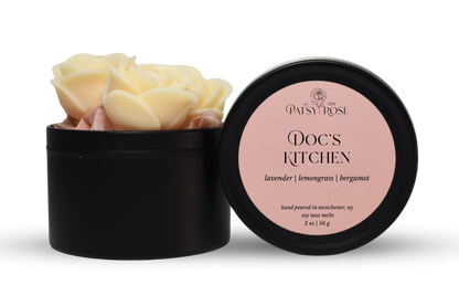 Hand-poured, rose shaped soy wax melts made by Patsy Rose with black tins and a peach label that says "Doc's Kitchen" with scent notes of "lavender, lemongrass, bergamot".