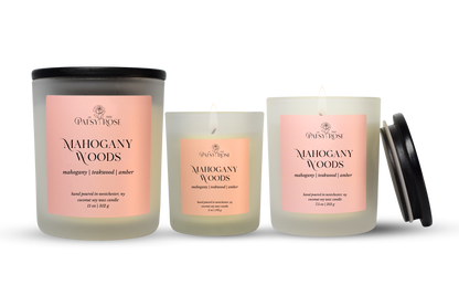 Three hand-poured coconut soy wax candles by Patsy Rose in the Mahogany Woods scent, shown in different glass sizes with a black lid on the largest jar and one smaller jar beside it, on a white background.