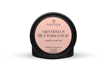 Hand-poured soy wax melts made by Patsy Rose with black tins and a peach label that says "Grandma's Butterscotch" with scent notes of "caramel, sea salt, oud".