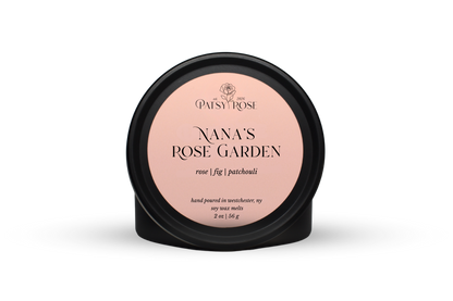 Hand-poured soy wax melts made by Patsy Rose with black tins and a peach label that says "Nana's Rose Garden" with scent notes of "rose, fig, patchouli".