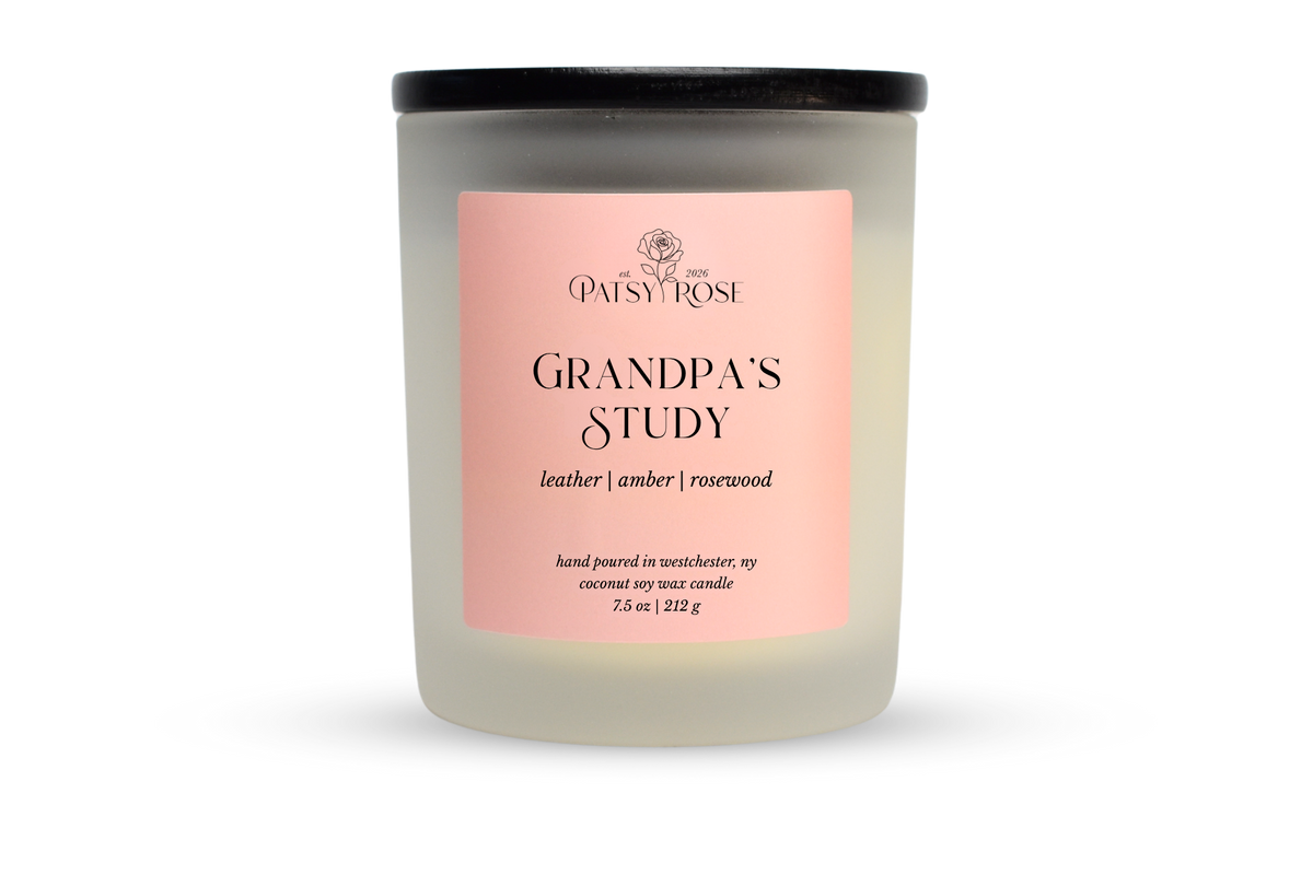 A 7.5 oz soy wax candle by Patsy Rose in the 'Grandpa's Study' 'leather | amber | rosewood' scent. The candle is in a frosted glass jar with a black lid and a peach-pink label, set against a plain white background.