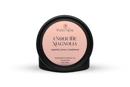 Hand-poured soy wax melts made by Patsy Rose with black tins and a peach label that says "Under the Magnolia" with scent notes of "magnolia, peony, sandalwood".