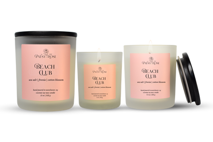 Three hand-poured coconut soy wax candles by Patsy Rose in the Beach Club scent, shown in different glass sizes with a black lid on the largest jar and one smaller jar beside it, on a white background.